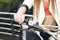 Female sitting on a motorcycle, hand on grip, outdoors.