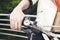 Female sitting on a motorcycle, hand on grip, outdoors.