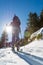 Female ski tourer ascending a forest slope.