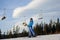 Female skier against ski-lift and forest on a sunny day