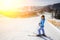 Female skier on the middle of ski slope against ski-lift