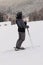 Female skier on the peak of mountain and she looking to the valley and enjoy the view. Special ski clothes colored to grey shadow