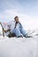 Female Skier Sitting On Deckchair In Mountains