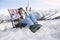 Female Skier Sitting On Deckchair In Mountains