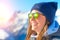 Female skier with skis smiling and wearing ski glasses