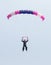 Female sky diver with brightly coloured open parachute gliding i
