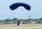 Female skydiver making safe landing on grass with open brightly