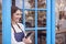 Female Small Business Owner With Digital Tablet Standing In Shop Doorway On Local High Street