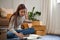 Female SME business entrepreneur packing her parcel in the living room, preparing shipping orders