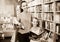 Female with smiling girl in school age picking books