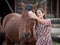 Female smiling while taking a selfie with a chestnut horse.