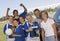 Female Soccer Player With Friends And Parents Holding Trophy