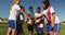 Female soccer team clasping hands together on soccer field. 4k