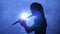 Female in spotlight in smoky studio plays on flute, silhouette