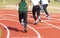 Female sprinters starting a race on an outdoor track from behind