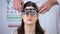 Female squeezing eyes, oculist putting refractor on smiling lady patient, lenses