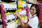 Female staff arranging goods in grocery section