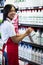 Female staff arranging milk bottle in shelf