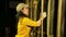 A female stage worker in gloves clamps the cable to lift the theater curtain