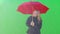 Female standing under umbrella waving to taxi