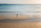 Female stands on a secluded beach at sunset