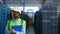 Female storage employee inspecting blue delivery boxes managing factory shipment