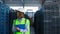 Female storage employee inspecting blue delivery boxes managing factory shipment