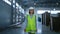 Female storage employee walking in factory storehouse checking distribution
