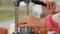 Female street vendor skillfully making freshly squeezed juice from oranges