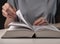 Female student hands close up, turning pages of thick book, searching for information and reading