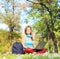 Female student with headphones working on a laptop in park