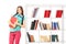 Female student leaning against a bookshelf