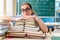 The female student with many books sitting in the classroom