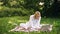 Female student outdoor. Girl works with a laptop sitting on a blanket in the park. Young woman with a studying outdoors.