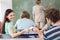 Female student passing note to friend in classroom