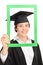 Female student posing behind a green picture frame