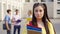 Female student posing near college building