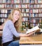 Female student reads the book in library.