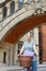 Female Student Riding Old Fashioned Bicycle Around Oxford University College Buildings By Bridge Of Sighs