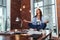 Female student sitting in lotus pose on table in her room meditating relaxing after studying and preparing for exam