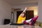 Female student studying on a laptop in living room. Girl stretching after finishing an online class. Home education concept