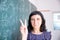 Female student or teacher in the classroom writing on chalkboard mathematical equations