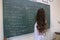 A female student writes on the blackboard in Turkish language course in classroom in one of the high schools