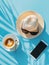 Female summer vacation set on blue background. Hat, phone and cappuccino. Vertical layout