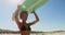 Female surfer carrying surfboard on her head 4k