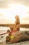 female surfer posing with surfboard on beach at sunset