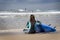 Female surfer sitting on the beach