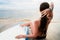 Female surfer sitting next to Board after Surfing at beach