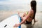 Female surfer sitting next to Board after Surfing at beach