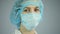 Female surgeon looking into camera with sad eyes, preparing to tell bad news